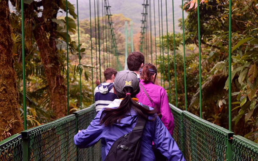 Students crossing a suspension pedestrian bridge in Costa Rica